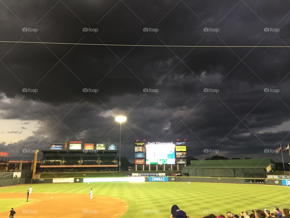 Baseball game with ominous clouds