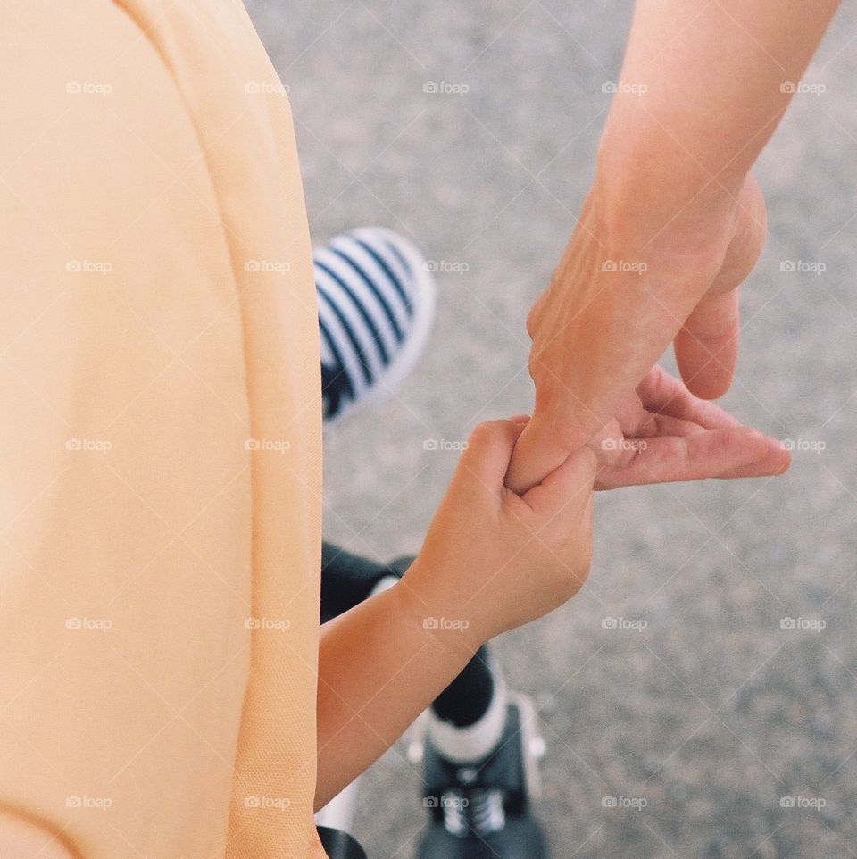 Baby and mother holding hands