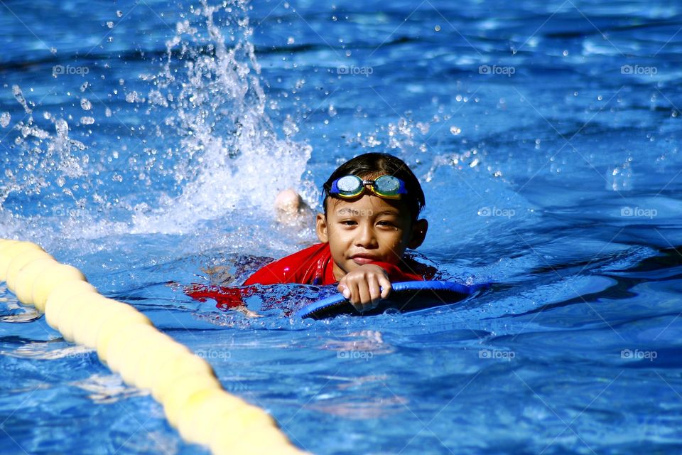 young kid swimming in a swimming pool