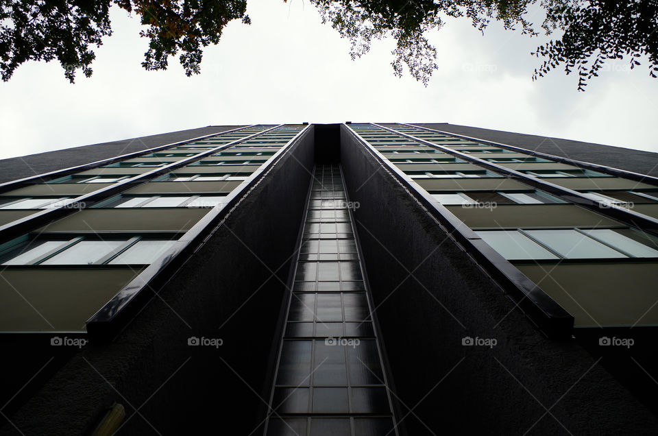 Low angle view of modern skyscraper against sky in Berlin, Germany.