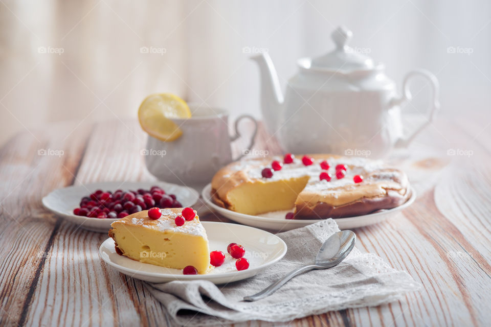 Cheesecake with cranberries and sugar on wooden background