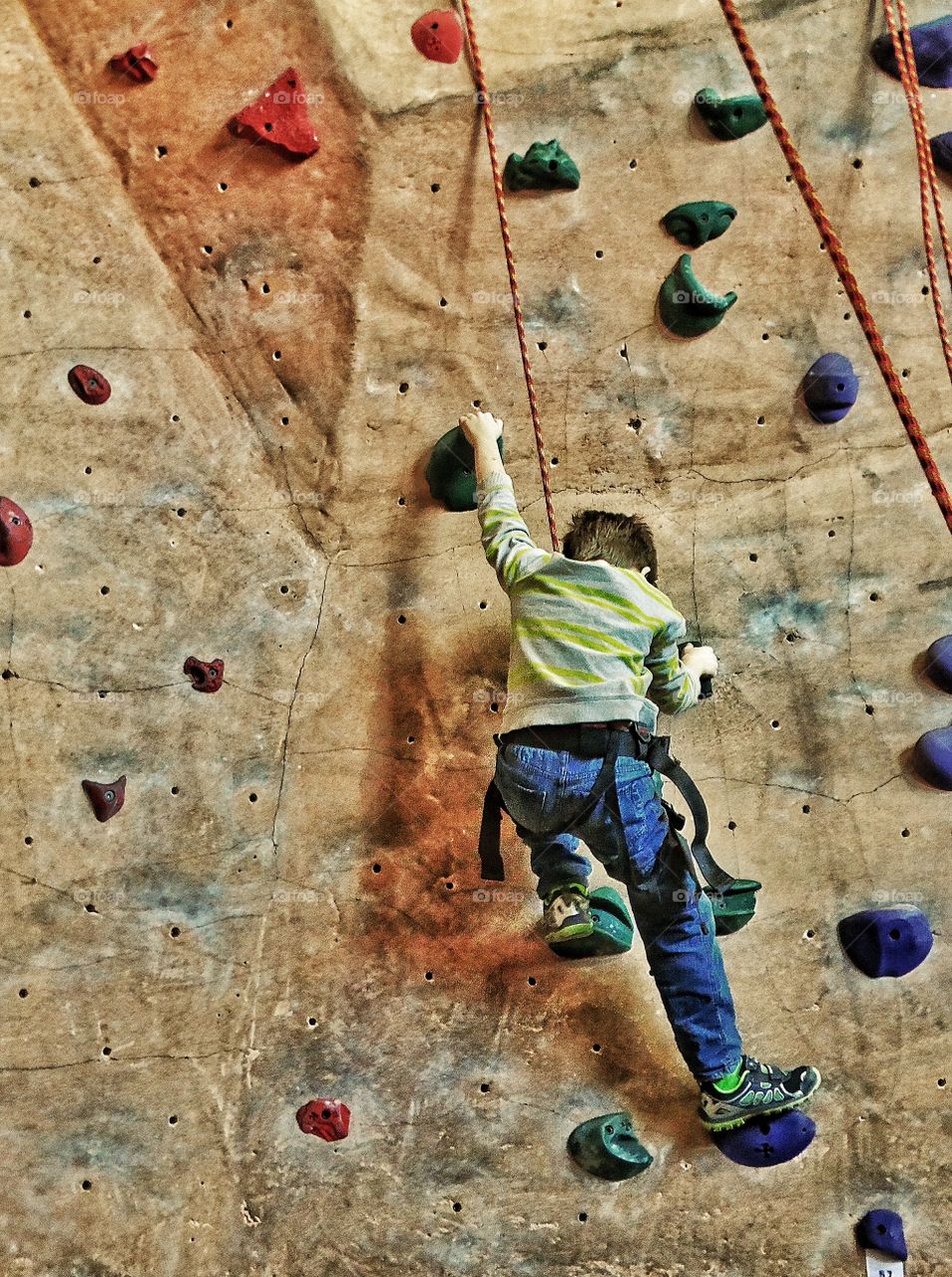 Boy Ascending A Rock Wall
