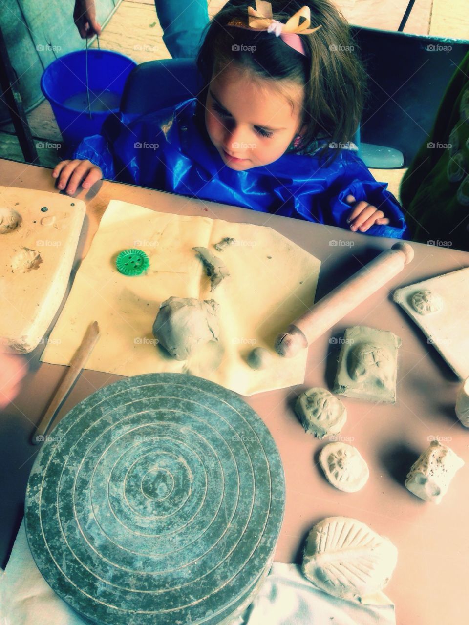 Child getting ready to sculpt clay at pottery school 