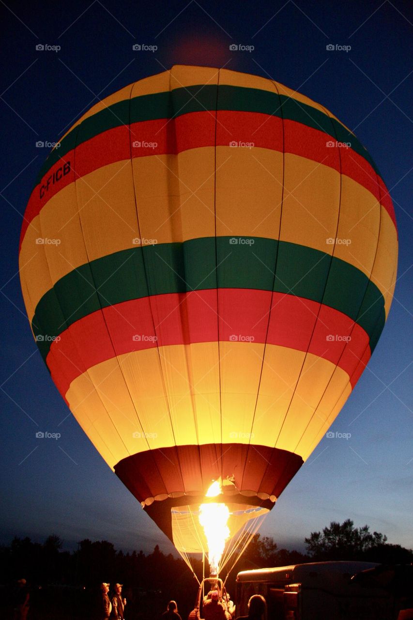 A hot air balloon glows in the night.