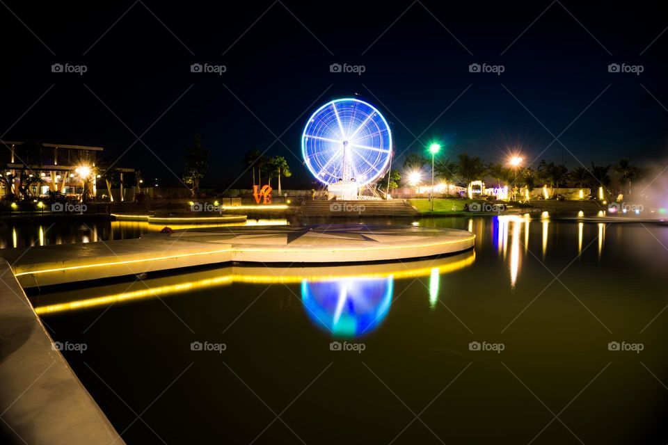 the reflection of the ferris wheel in the water is created by the long exposure technique