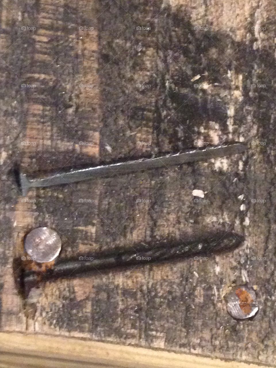 A nail flattened into a plank of wood