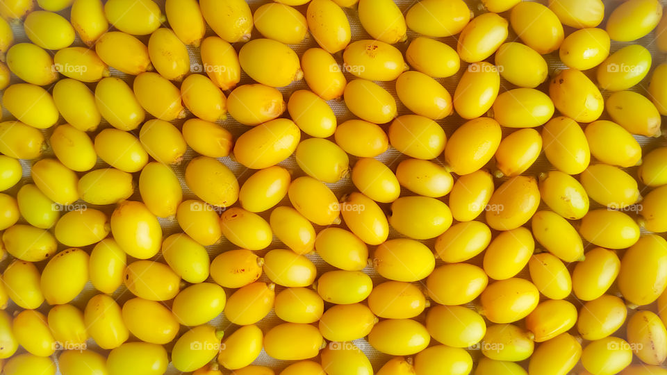 Neem fruits texture background full frame.Texture of yellow Neem fruits.