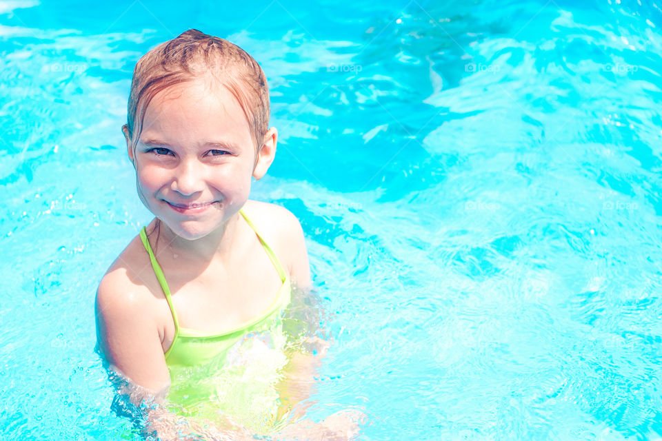 Girl in swimming pool. Little girl in swimming pool at sunny summer day