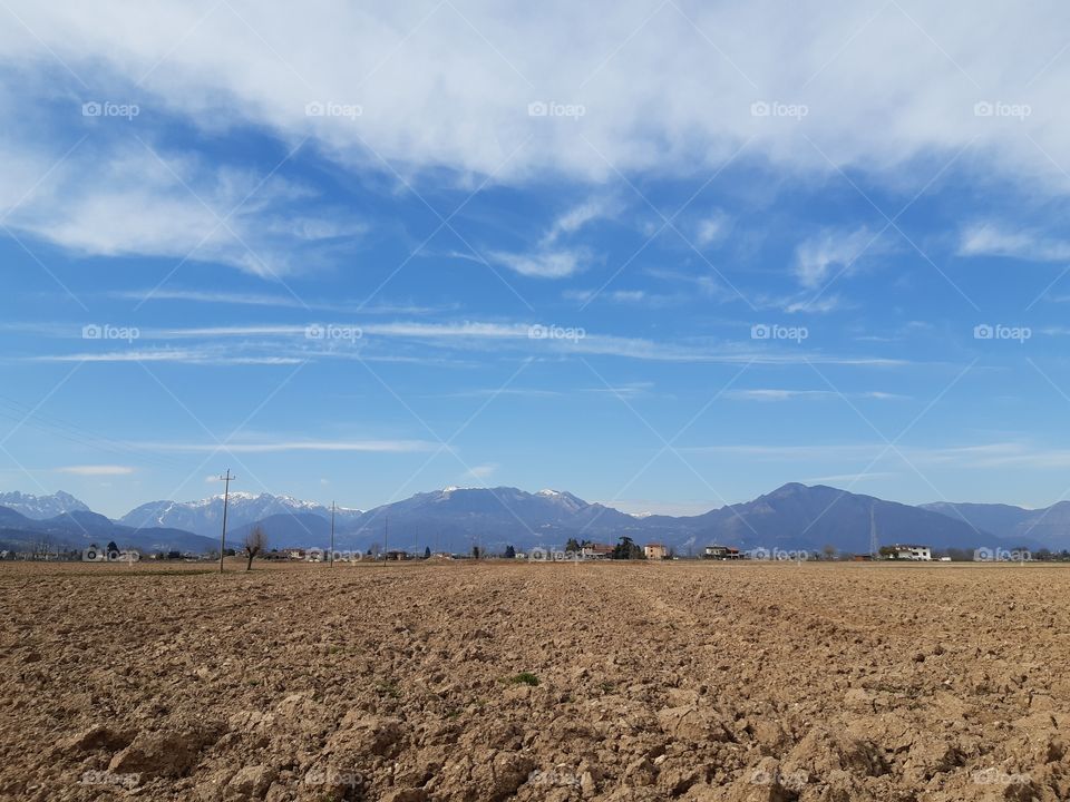 plowed field under a cloudy sky