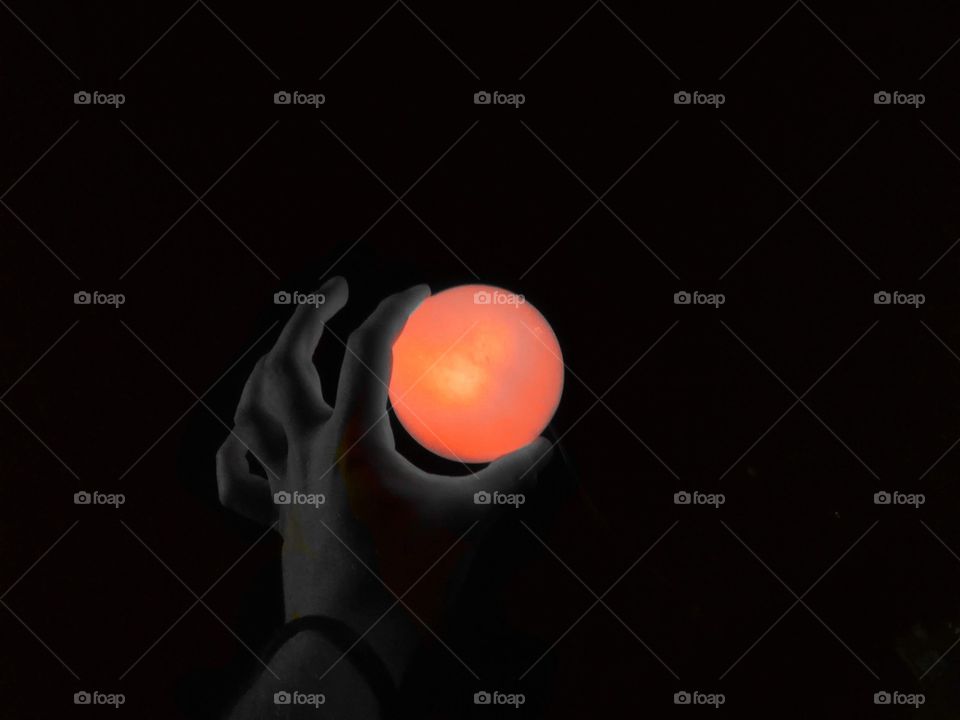 Red moon, sun, the illusion of it is a hand on the heart