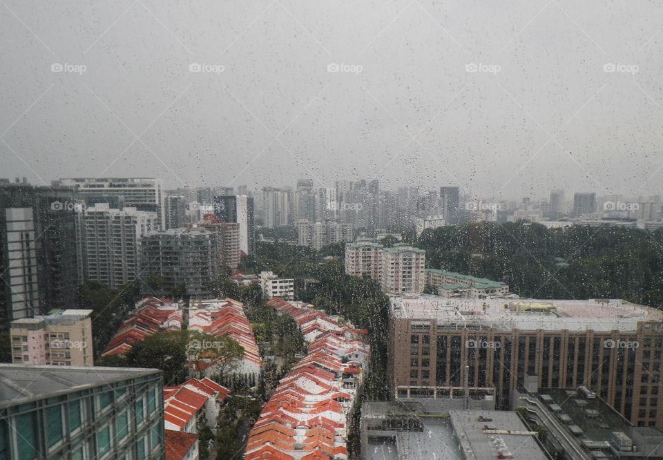 Rainy day, view from above to the city through the wet window