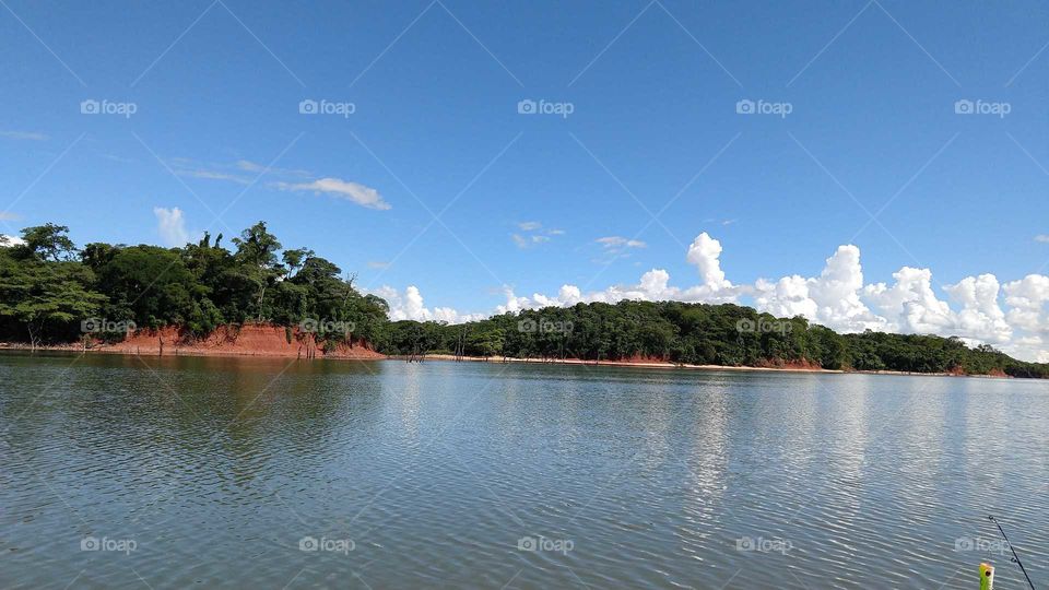 Uma paisagem de águas com o céu azul nublado.