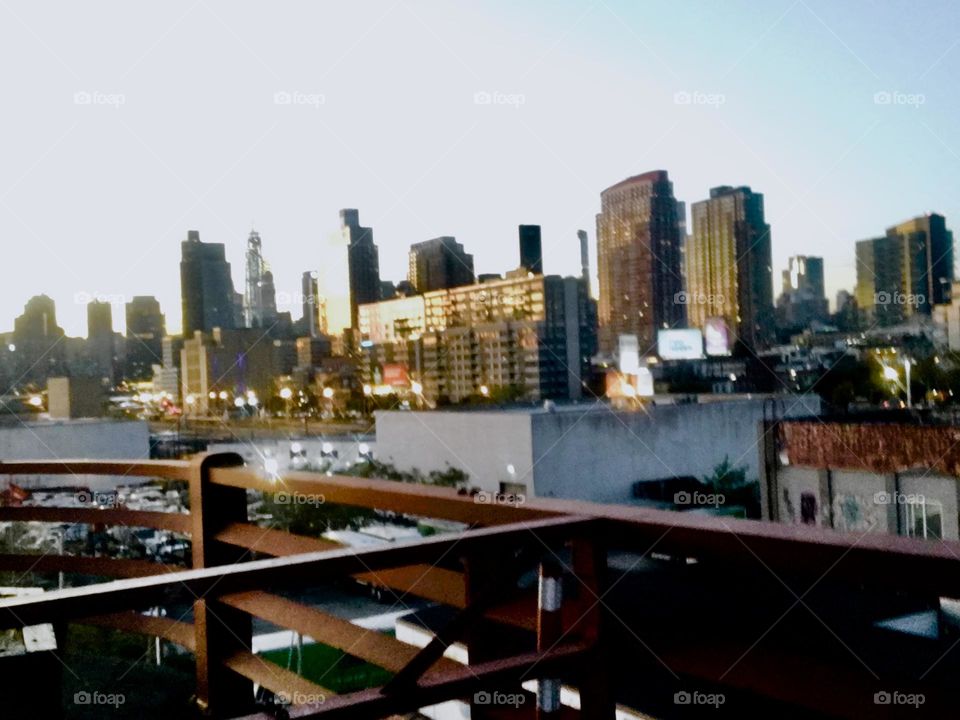 Newtown Creek in Long Island City in Queens, New York seen from atop the Pulaski Bridge in the twilight hour of upcoming nightfall. In the distance you can see parts of Queens as well as the Manhattan skyline. 2019. Hypnotic Productions