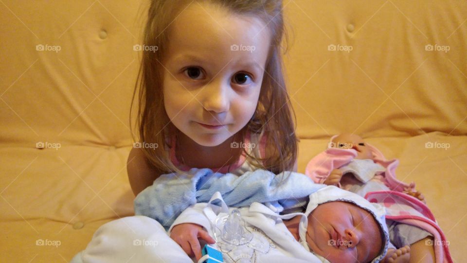 Sister with new born child on sofa