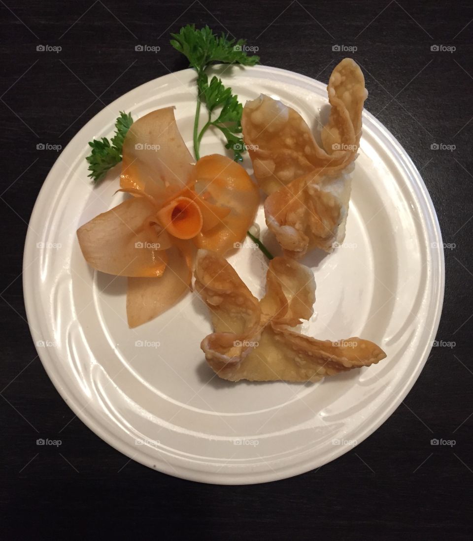 Cream cheese wontons daffodil . Cream cheese wontons with a daffodil carrot garnish. 
