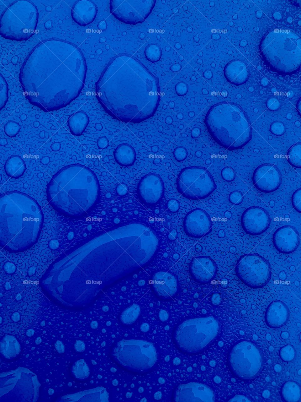blue surface wet with water with large drops highlighted to form a texture