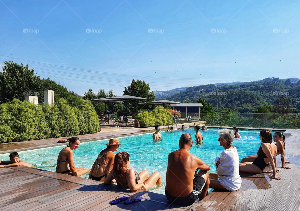 Family and friends enjoying a beautiful summer day around the swimming pool... This is happiness!
