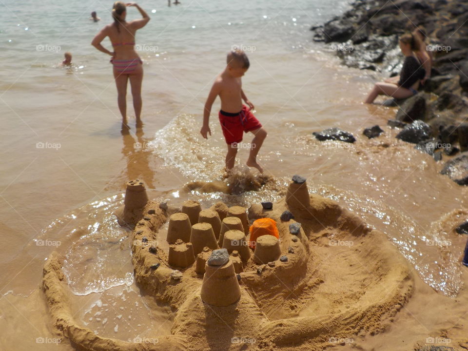 Tide reaching sandcastle 