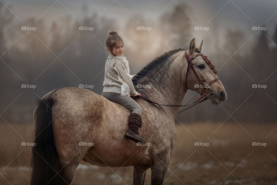 Portrait of little girl with  horse