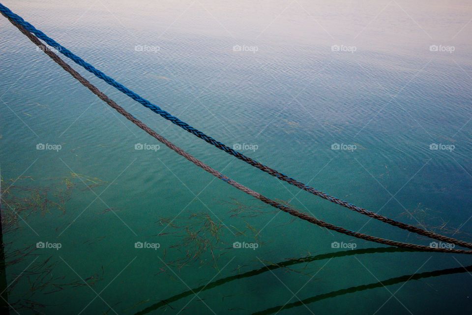Water turned into green color and a reflection of  a rope appears on the surface