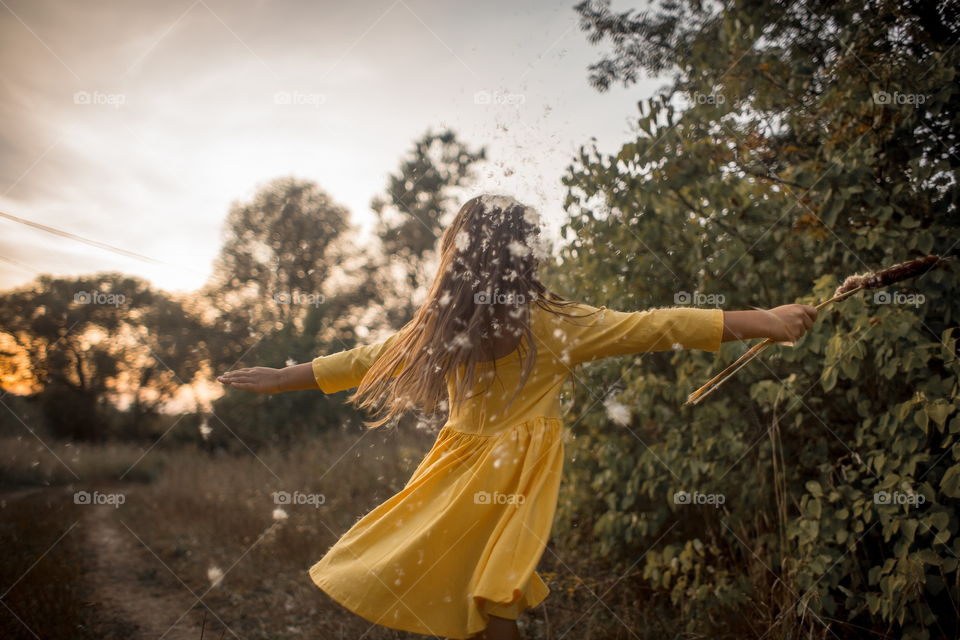 Little girl in yellow dress outdoor portrait at sunset 