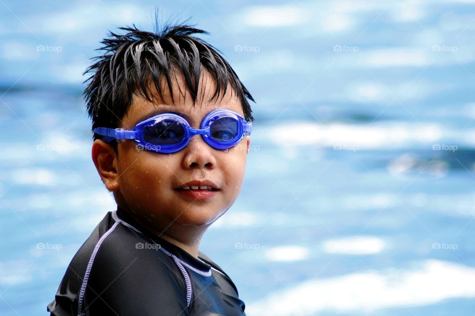 young boy with goggles in a swimming pool