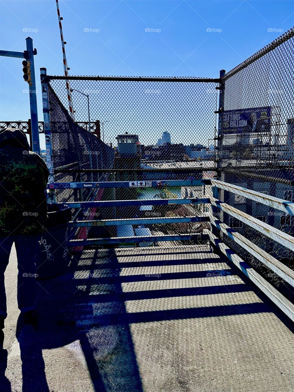 This is the top of the staircase of the “Pulaski Bridge” at “Newtown Creek” in LIC, Queens leading to the pedestrian lane to the left crossing over to “Greenpoint”, Brooklyn. Structures and shadows weave a cubist theme. 2023. Hypnotic Productions
