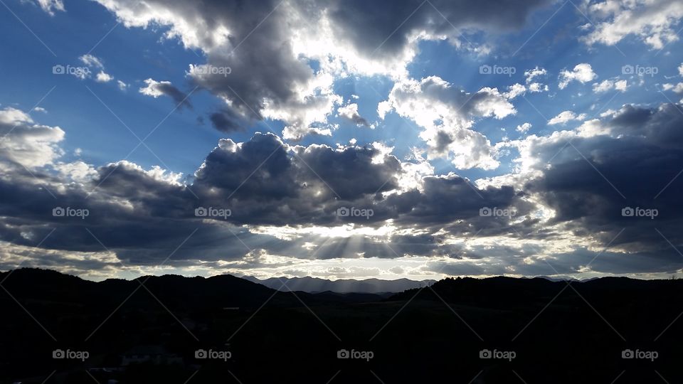Sun shining through cumulus clouds