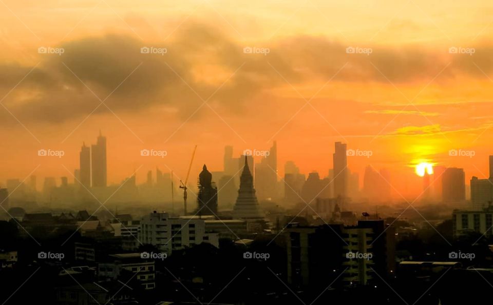 A stunning sunrise over the skyline of Bangkok, Thailand. Wat Paknam and its large Buddha can be seen in the foreground.