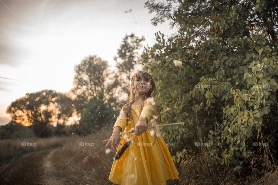 Little girl in yellow dress outdoor portrait at sunset 