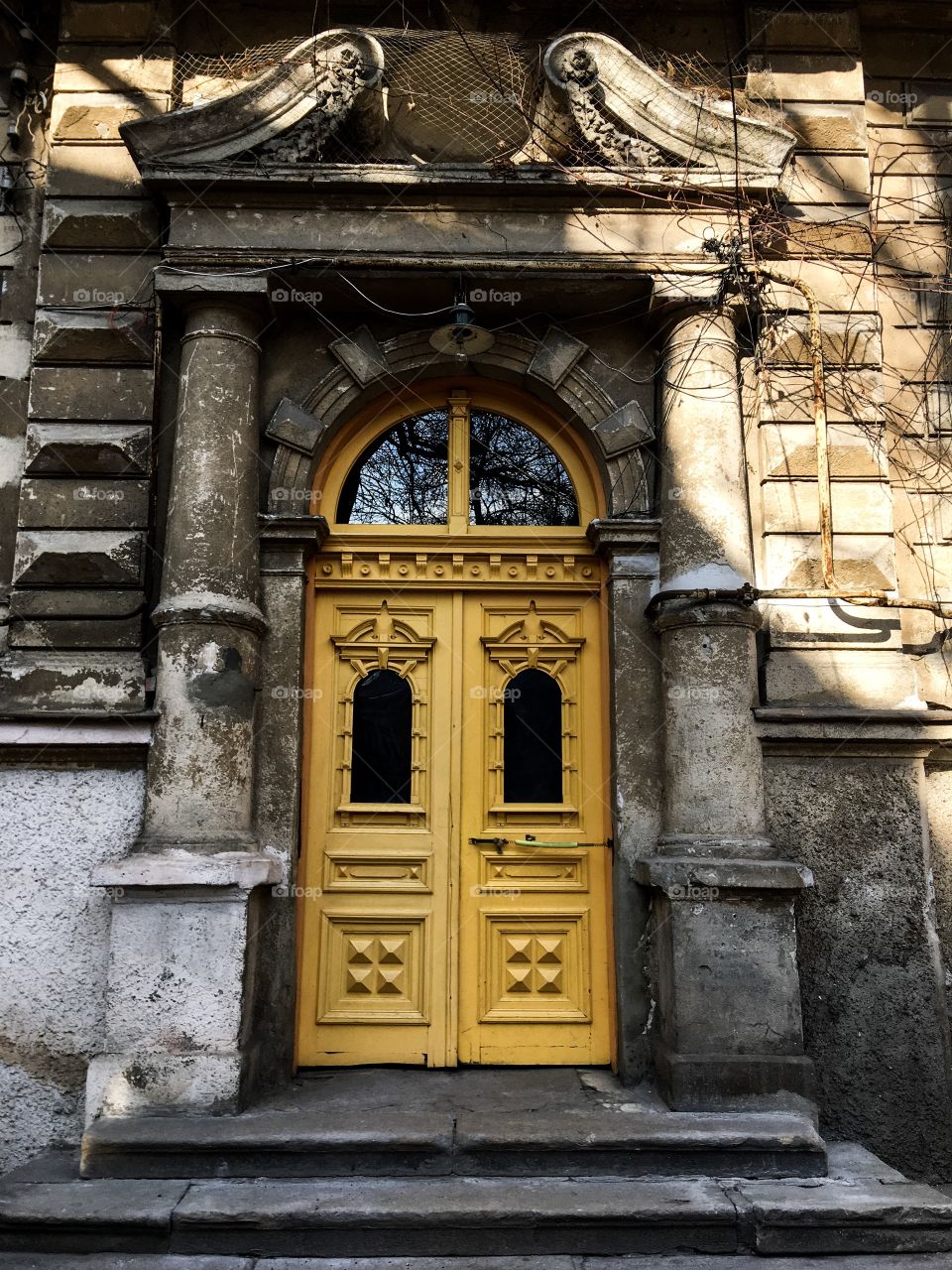 The vintage yellow wooden entrance door. Odessa city, Ukraine. Old tip yak yard. 