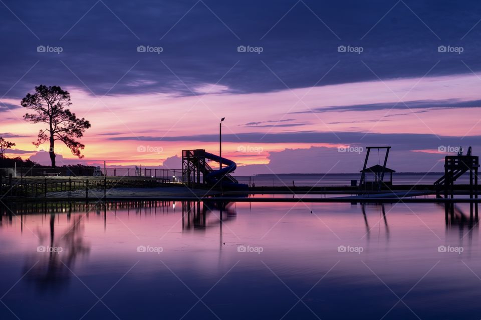 Vivid colors paint the sky and the reflection on the pond during sunrise at Camp Seagull in North Carolina. 