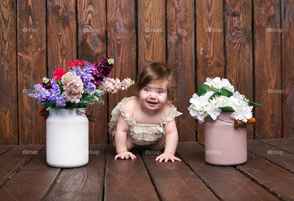 Baby girl crawling on wooden floor