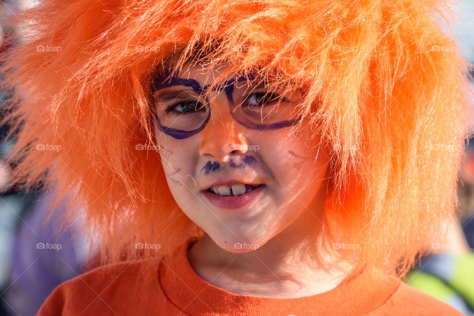 Portrait of smiling boy with orange wig