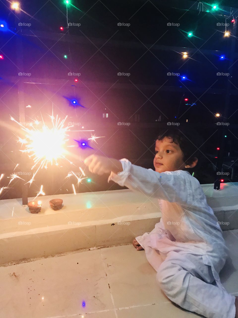 Indian baby boy wearing Indian traditional dress and lighting crackers on famous Indian festival Diwali.