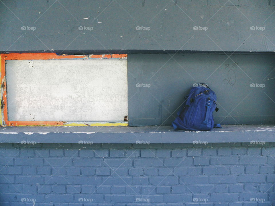 blue backpack on a gray wall background