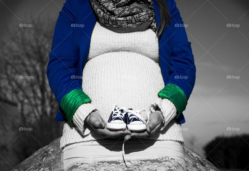 pregnant woman with baby shoes