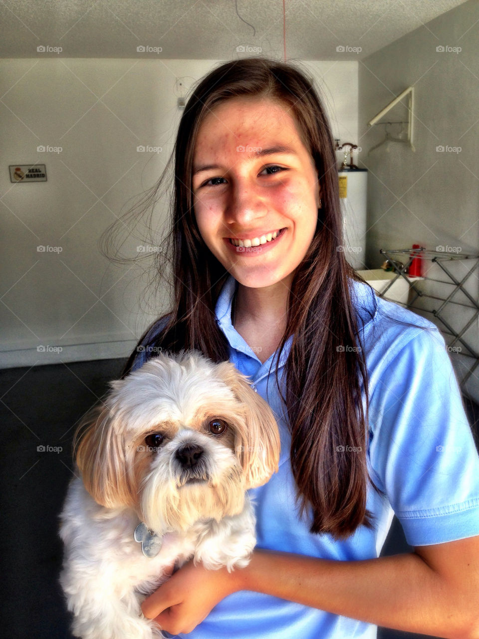 Girl holding a dog smiling