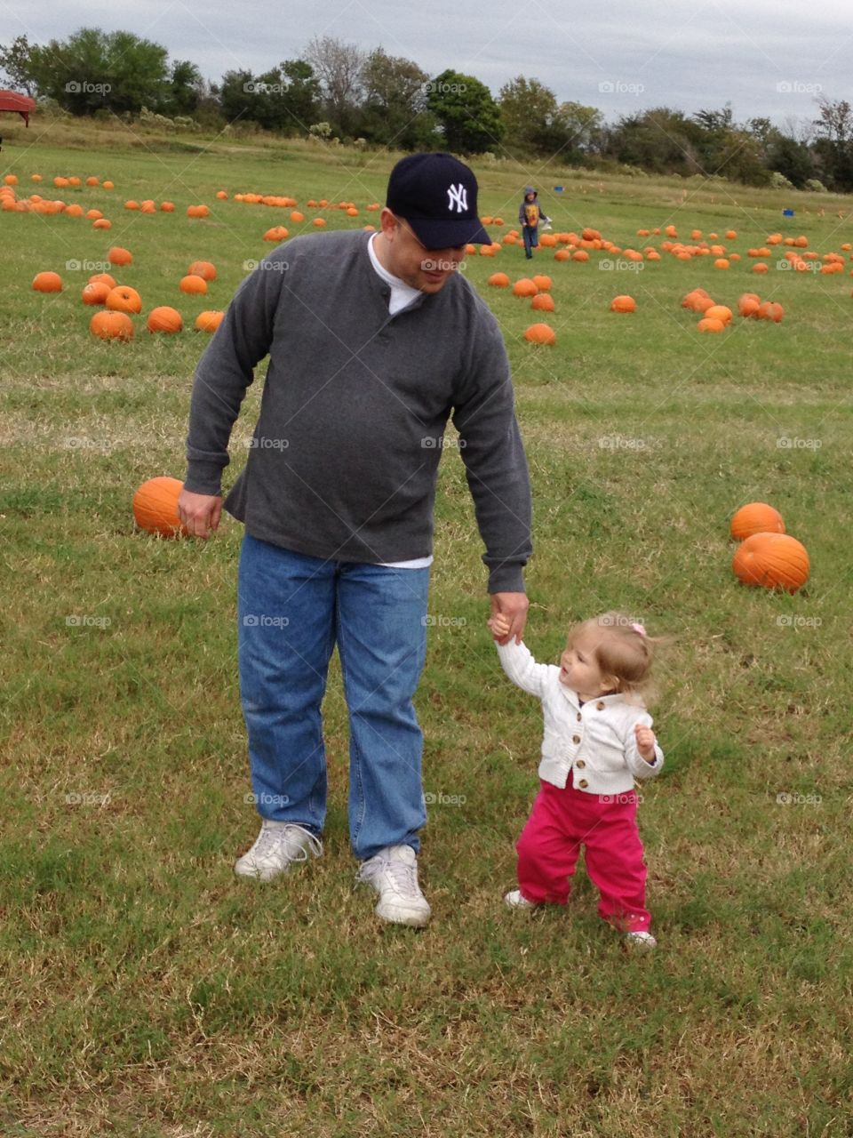 Walking through the pumpkins with daddy. 