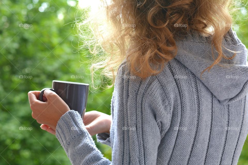 cup in the hands girl green background