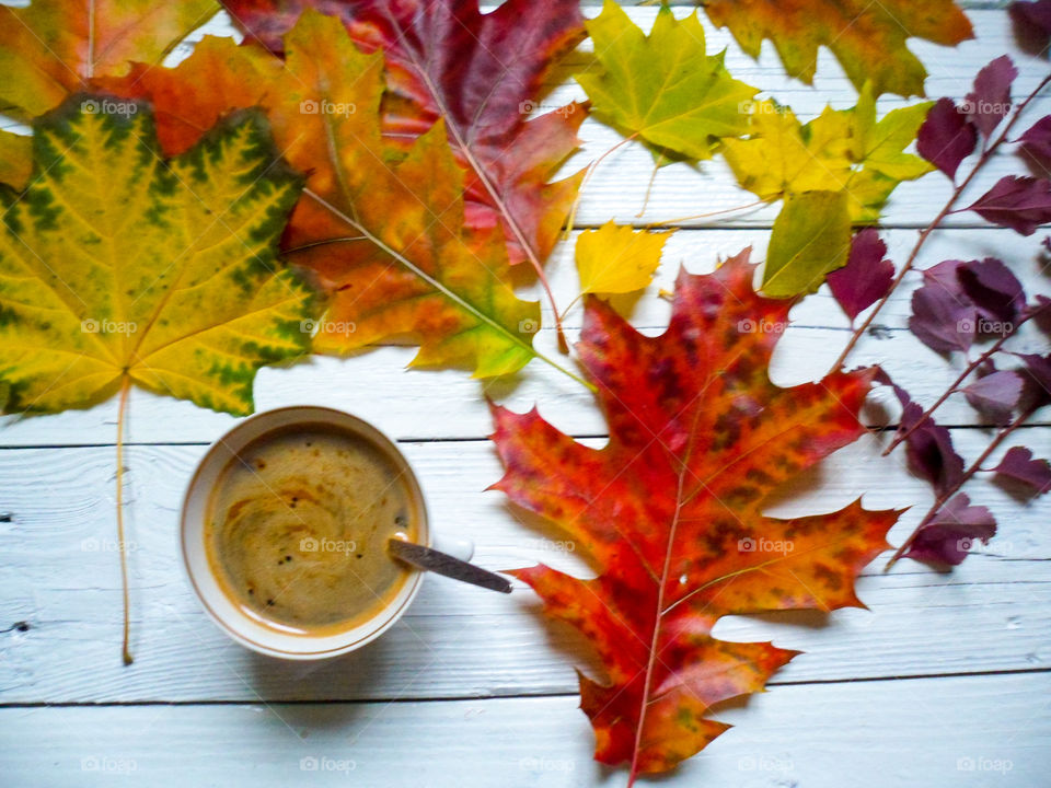 coffee with foam and autumn colorful foliage