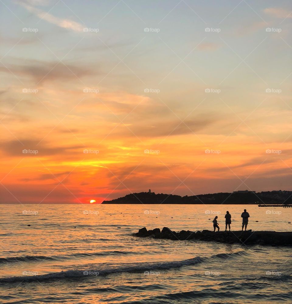 Beach sunset with silhouette of a family 
