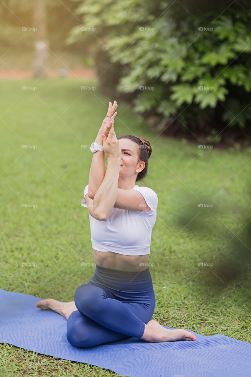 Happy woman exercising yoga outdoors 