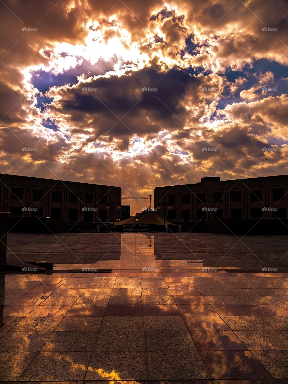sun down 🌞 behind clouds ☁️ ☁️ in circular shape with shadows and lights in-between