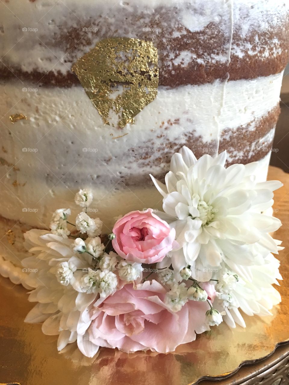  Baked cake decorated with real flowers and a thin layer of vanilla frosting