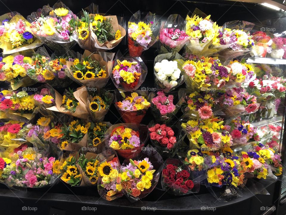 Many bouquets of flowers all different bright colors. 