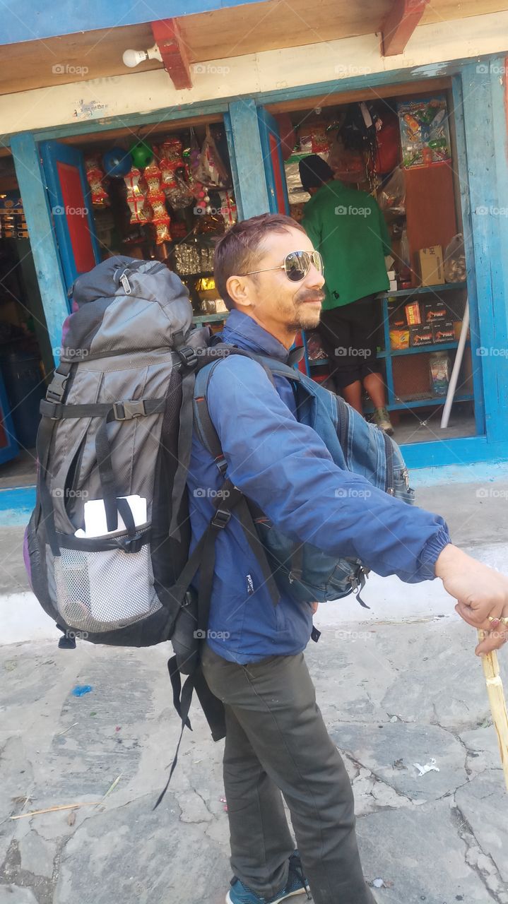 A person who is travelling in the mountains with heavy loaded bag.