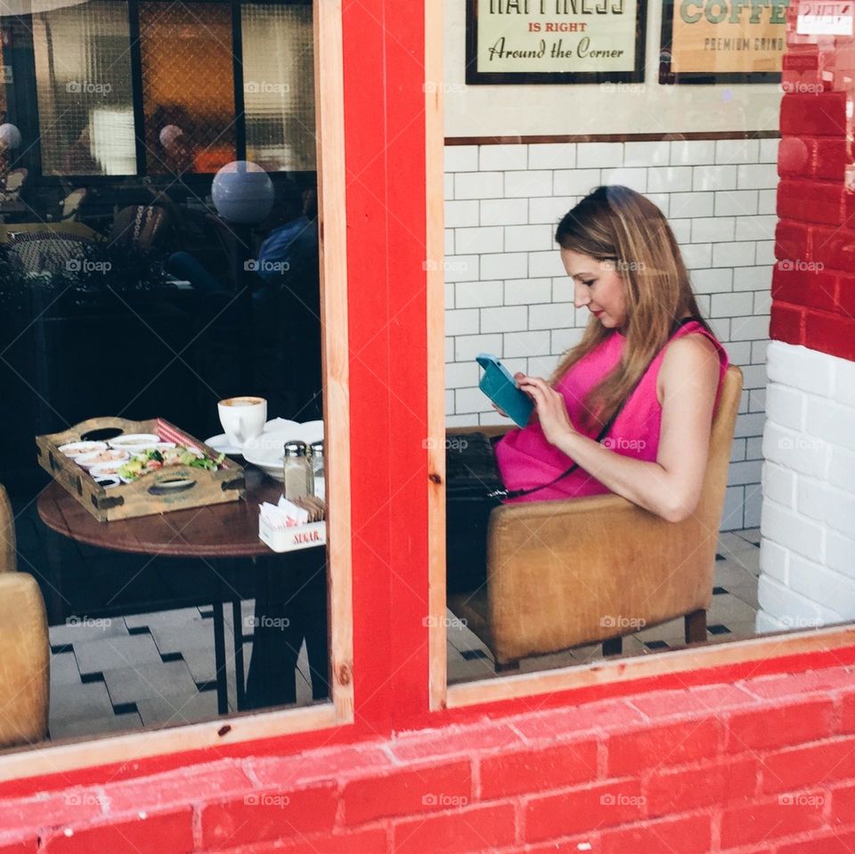 Women using mobile phone at the window 