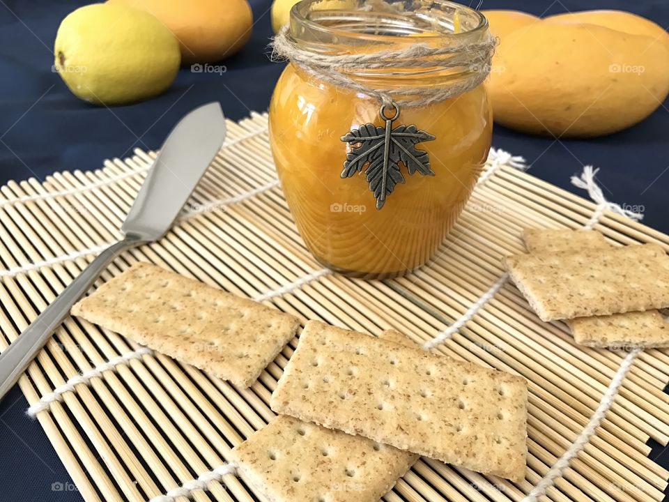 Mango jam with crackers on bamboo plate mat