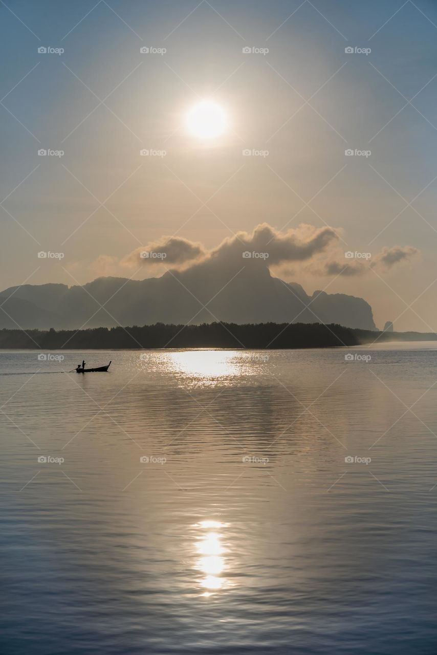 Beautiful Sunrise moment above silhouette of boat in sea